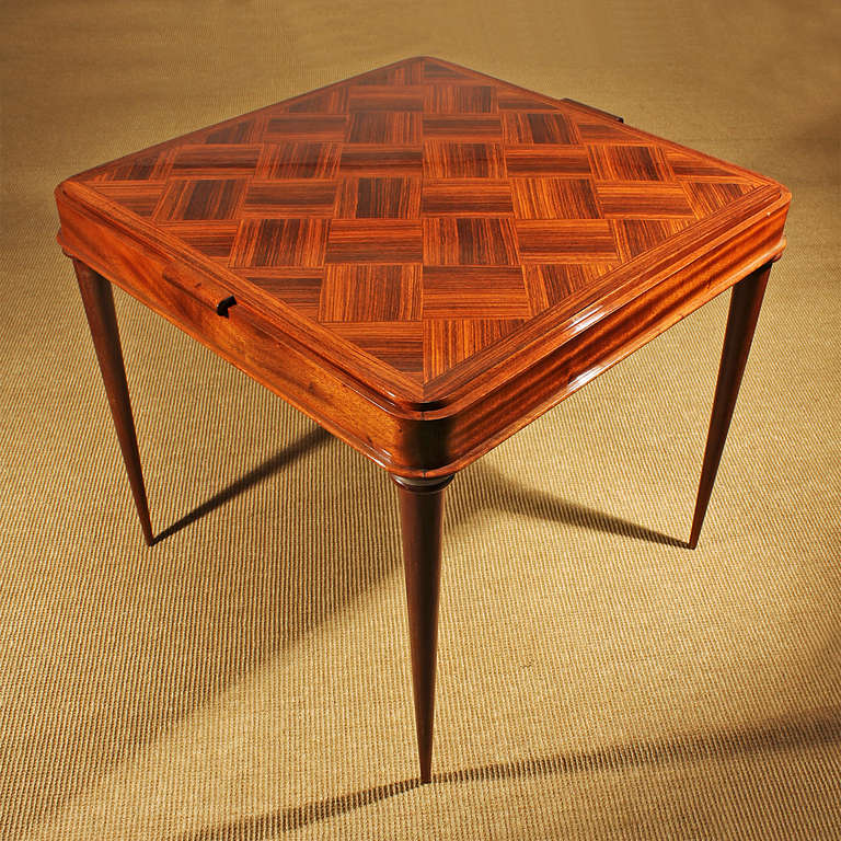 Game table, mahogany frame and feet with nickel plated brass rings, dark rosewood marquetry top with green felt in the backside, 

France circa 1940.