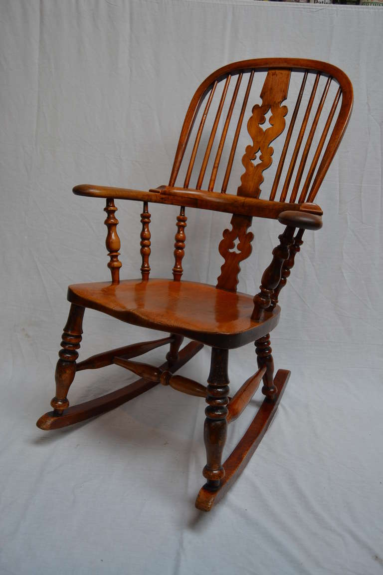 A classic broad arm windsor rocking chair made from ash and elm with a yew wood center splat and saddle-shaped seat with very rich patina and totally original. An absolutely prime example of this classic chair, a beauty.