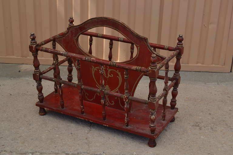 A very attractive magazine rack, polychromed in china red and gilt, patina very good, in original condition-definitely Shabby Chic.