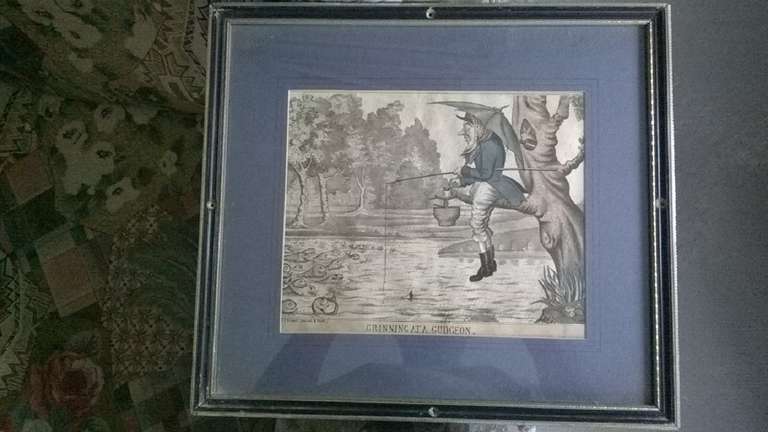 A satirical 19th century Fine Hand coloured etching, 
 
An angler sitting on the branch of a tree overhanging a river in the rain, open umbrella over his shoulder, peering at a shoal of gudgeon grinning at him just out of reach of his hook.

By