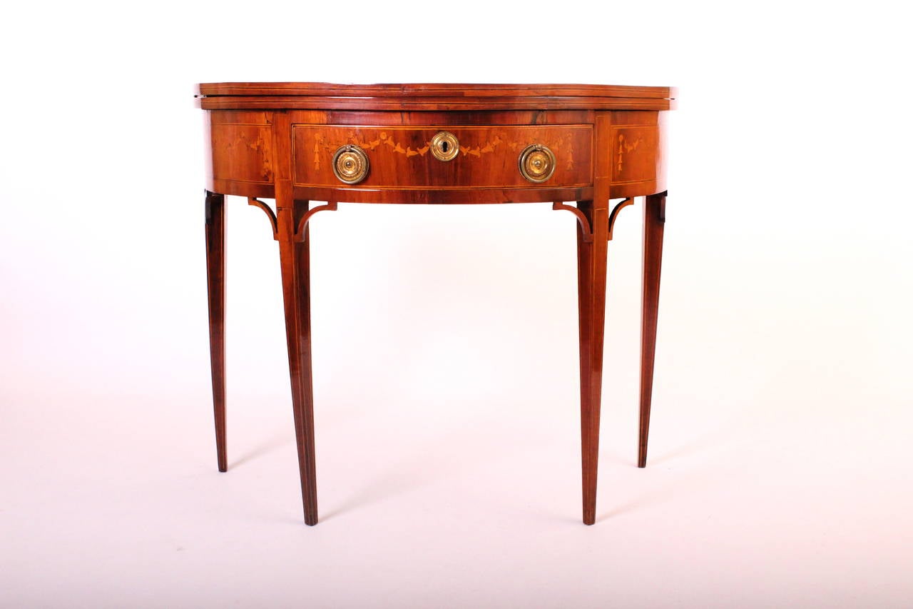 This games table presents a superb box wood inlaid top showing a noble man on a horse and flowers.