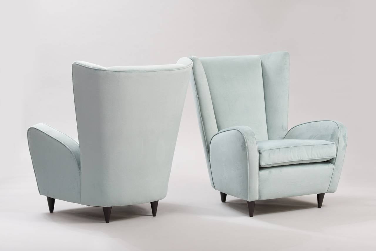 A pair of armchairs, re-upholstered in blue velvet.