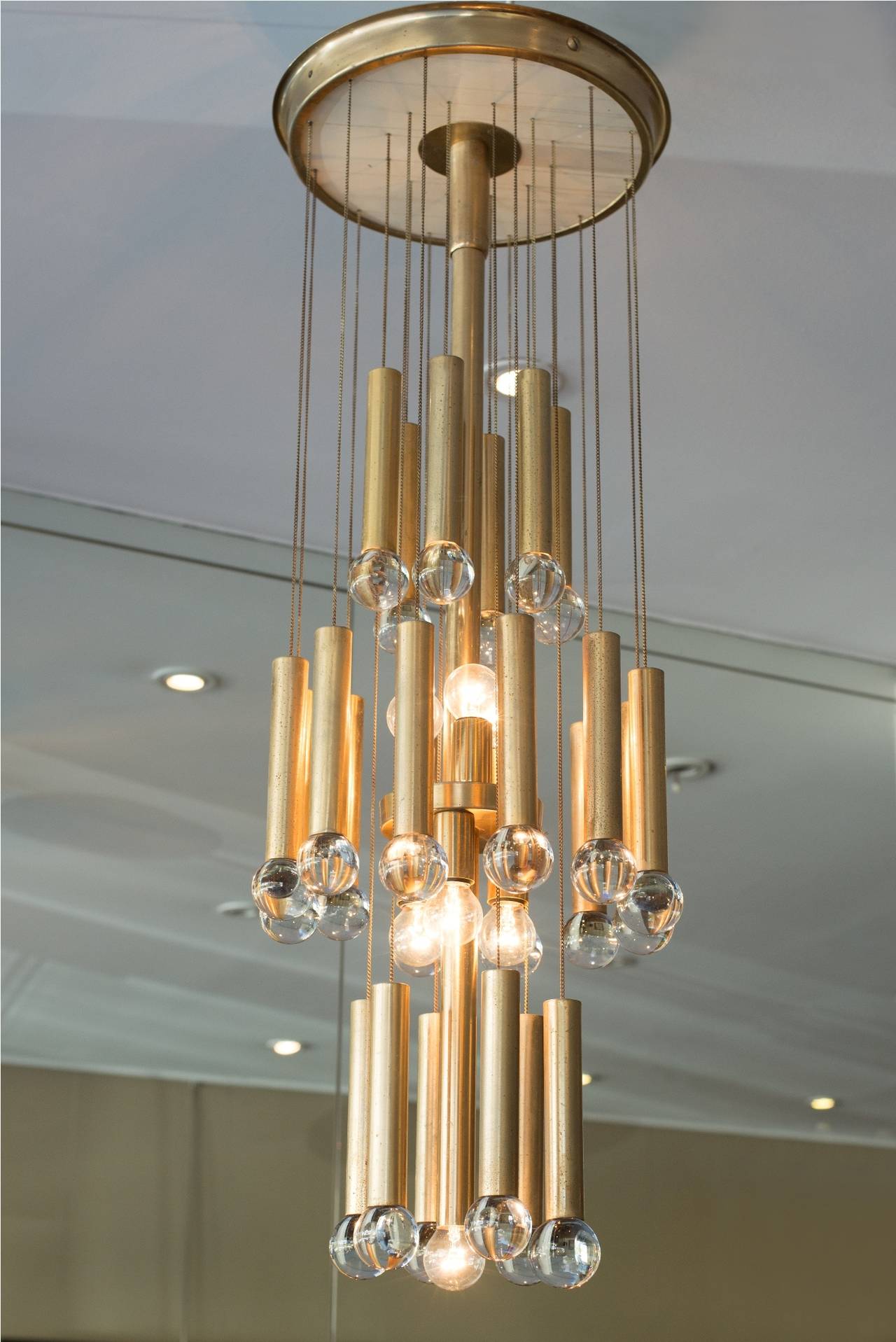 Brass color anodized aluminium and transparent glass balls chandelier.