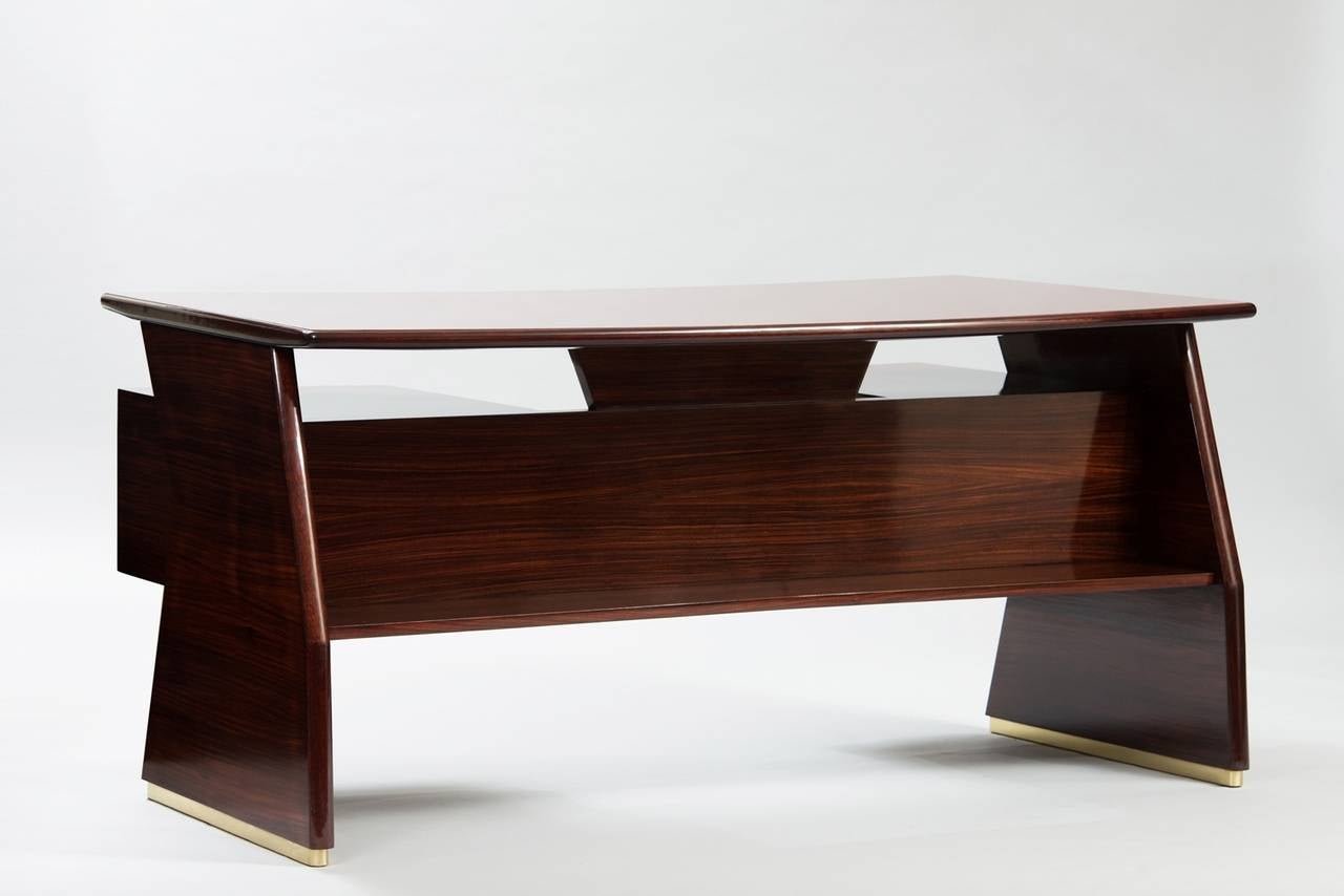 Rosewood boomerang shape desk with Bordeaux glass top and brass hardware.