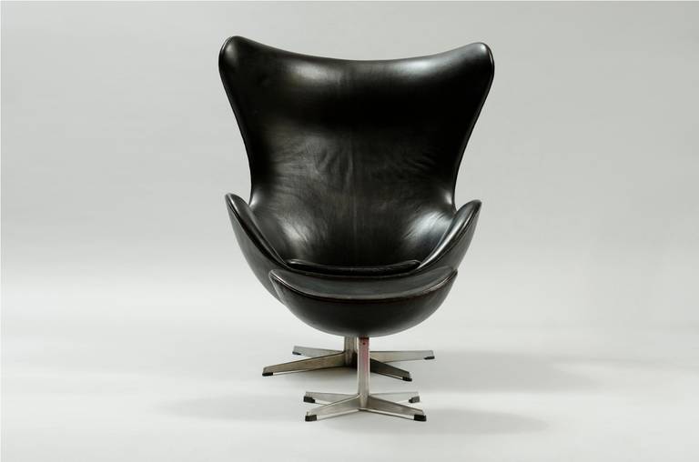 Egg chair and ottoman in black leather both in a moulded aluminium foot.
Producer: Fritz Hansen.