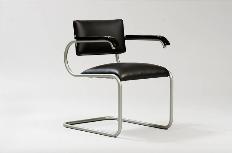 Modernist desk chair re-upholstered in black leather with a lacquered metal tube structure.