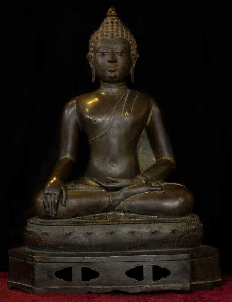 Thailand Chiang, Sheng reign 14th-15th century bronze with brown patina and vestigial gilded and polychrome. Maravisaya Buddha seated in varajsana over a lotus pattern base with a hexagonal platform in open work front holes. Dressed with a simple