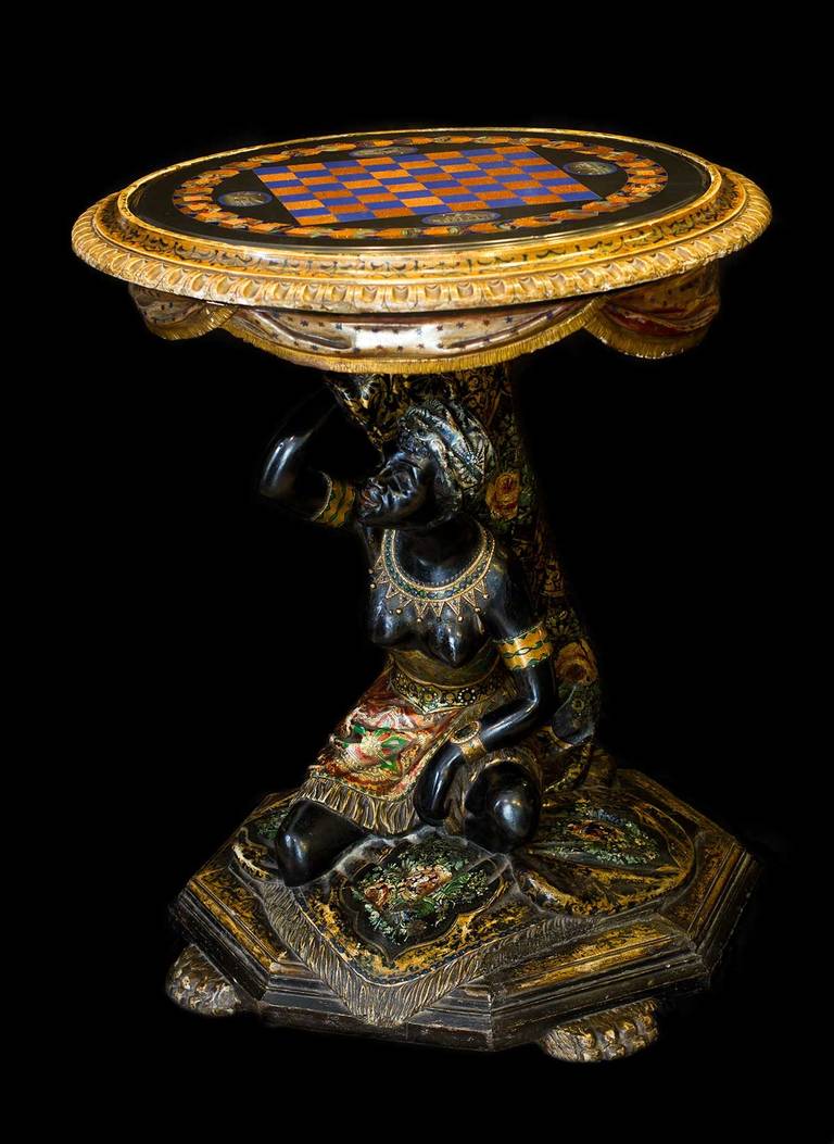 Tabletop with chess board layout, some architectural and geometric motifs. The stand is in the form of a woman.