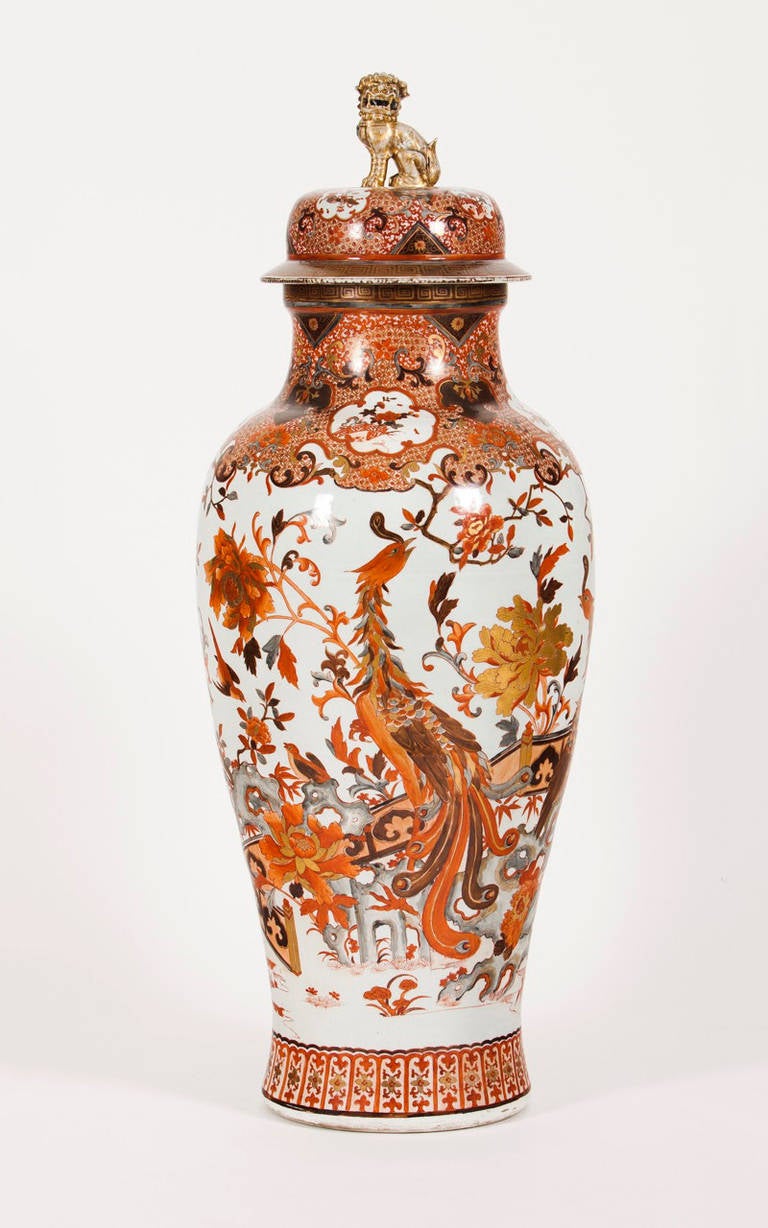 A large and impressive Chinese porcelain palace vase with profuse enameled decoration in iron red and gold representing phoenixes and different flowers branches. Golden Foo dog lid handle shaped.
Qianlong period of the Qing dynasty, 18th century.