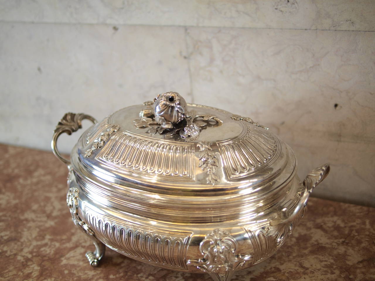 D. José silver tureen clearly french influenced with relief and grooved work
In the interior a silver tray and lid decorated with fruits flowers and foliage
Shell shaped handles and scroll feet
Mark of the Lisbon based dutch silversmith Henrique