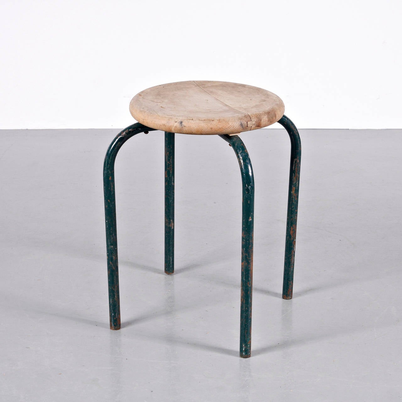 Stool designed in the manner of Jean Prouvé, circa 1950.
Manufactured in France.
Lacquered metal base and laminated wood seat.

In good original condition, with minor wear consistent with age and use, preserving a beautiful patina.