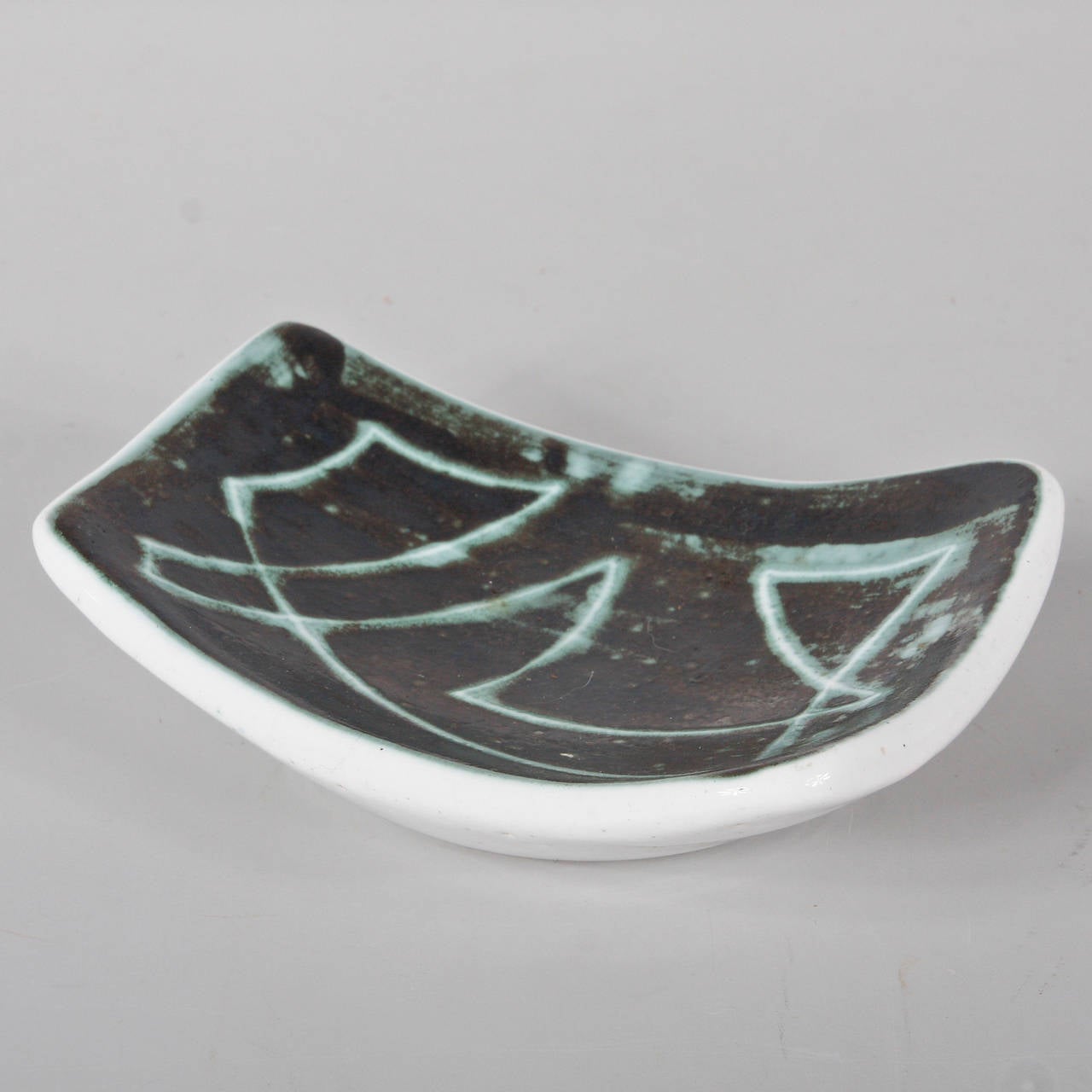 Beautiful ceramic dish glazed in green with an abstract drawing in the manner of Georges Jouve.
Manufactured in France, circa 1960.