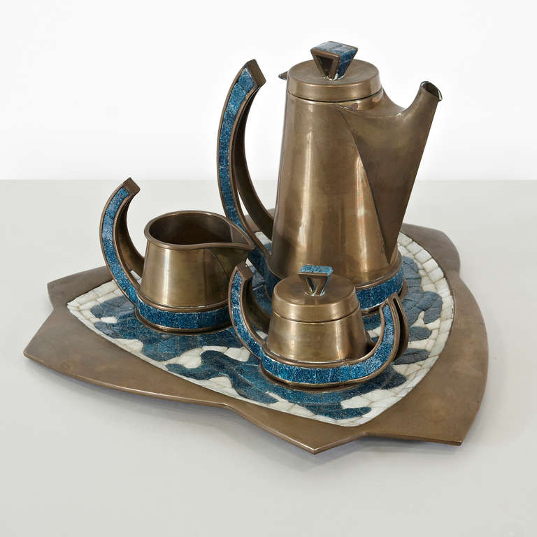 Coffee or tea set designed by Salvador Teran, circa 1952.
Manufactured by hand in Mexico, circa 1960.
Comprising a coffee pot, sugar bowl, creamer and tray, all of hand-wrought brass and glass mosaic. All in excellent original