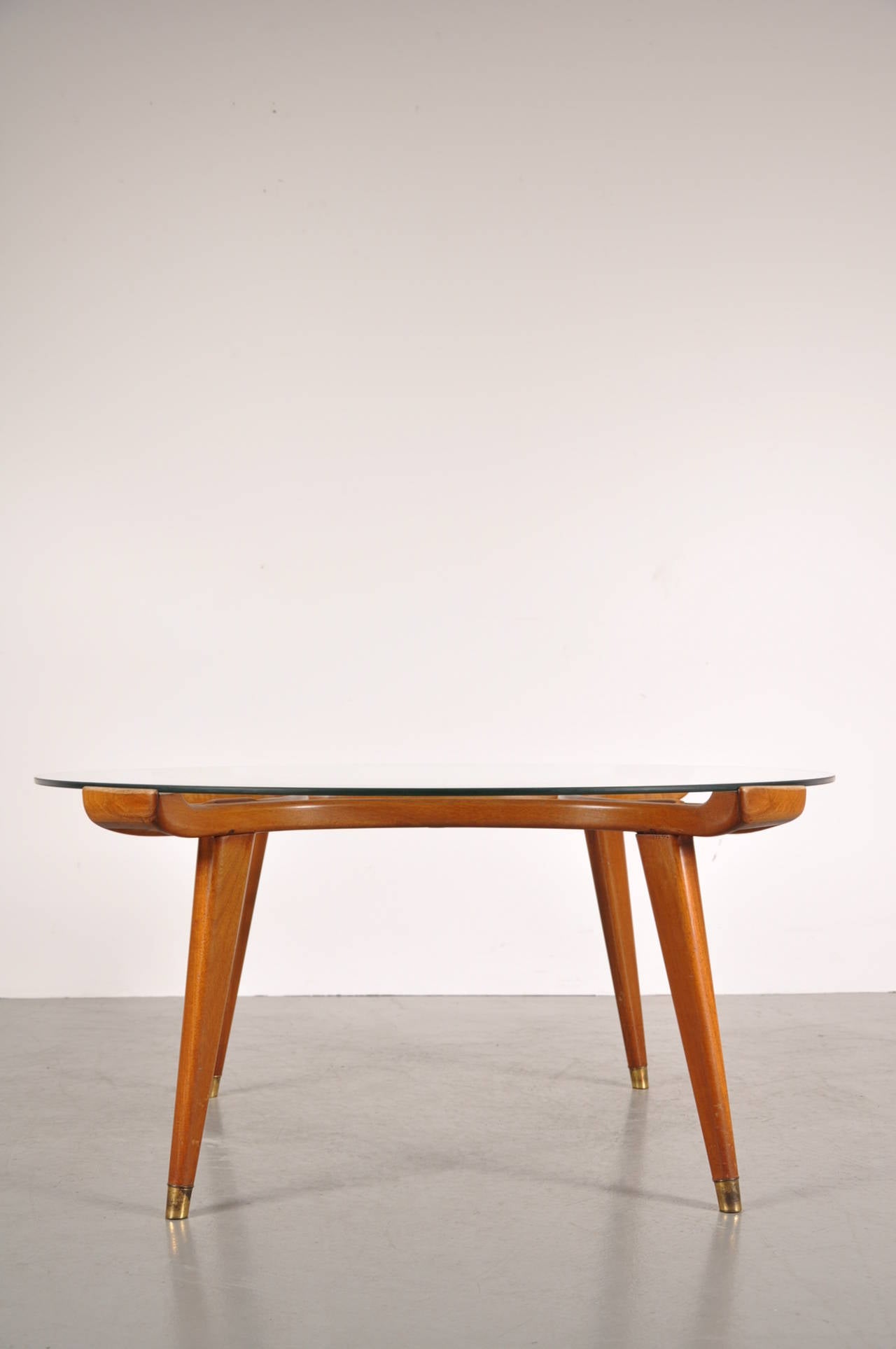 A fantastic round coffee table designed by William Watting and manufactured by Fristho in the Netherlands around 1950.

Made of high quality walnut wood with brass details and a beautiful finish with curved shapes. The clear round glass top adds