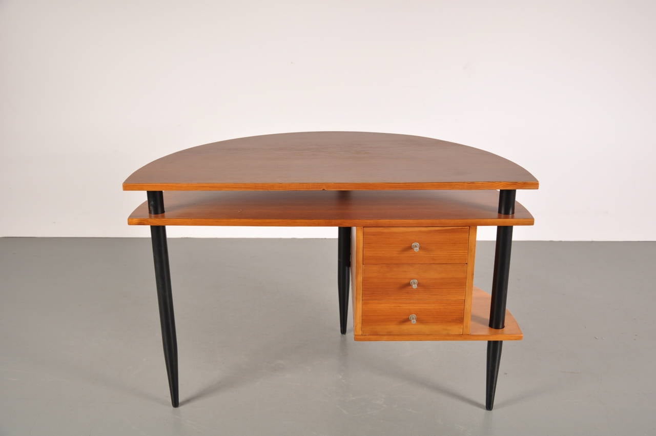 Stunning Scandinavian wooden desk in the manner of Ilmari Tapiovaara, manufactured around 1950.

The desk is made of high quality pine wood and has three drawers with beautifuly crafted metal handles and three black wooden legs.

In very good