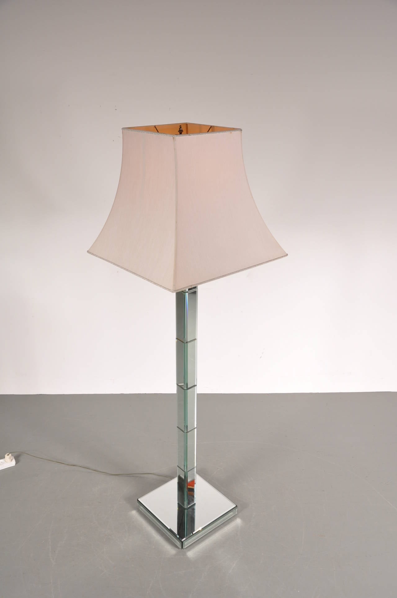 Beautiful floor lamp in the manner of Maison Jansen, manufactured in France around 1940.

This unique piece has an eye-catching mirror base on all sides, causing it to naturally blend in any interior. The glass is still in very good condition. It