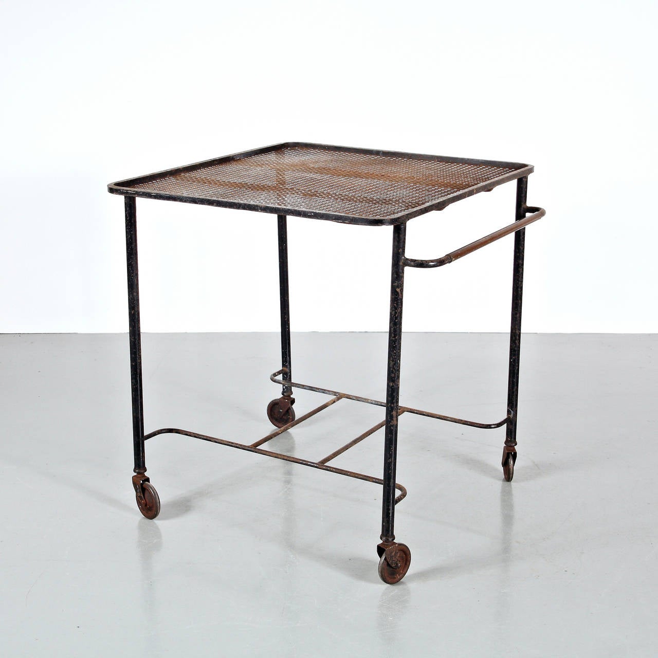 Tea Trolley designed by Mathieu Matégot.
Manufactured by Ateliers Matégot (France) circa 1950.
Folded, perforated metal lacquered in black and brass detail.

In good original condition, with minor wear consistent with age and use, preserving a