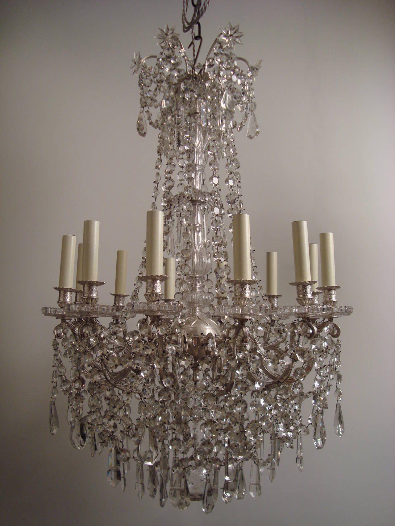 A most attractive silvered bronze, glass and crystal chandelier,  attributed to Baccarat. Of very well know model by Baccarat of the Belle Epoque, the silvered bronze central ball inspired from the Empire period and projecting 14 arms of light, each
