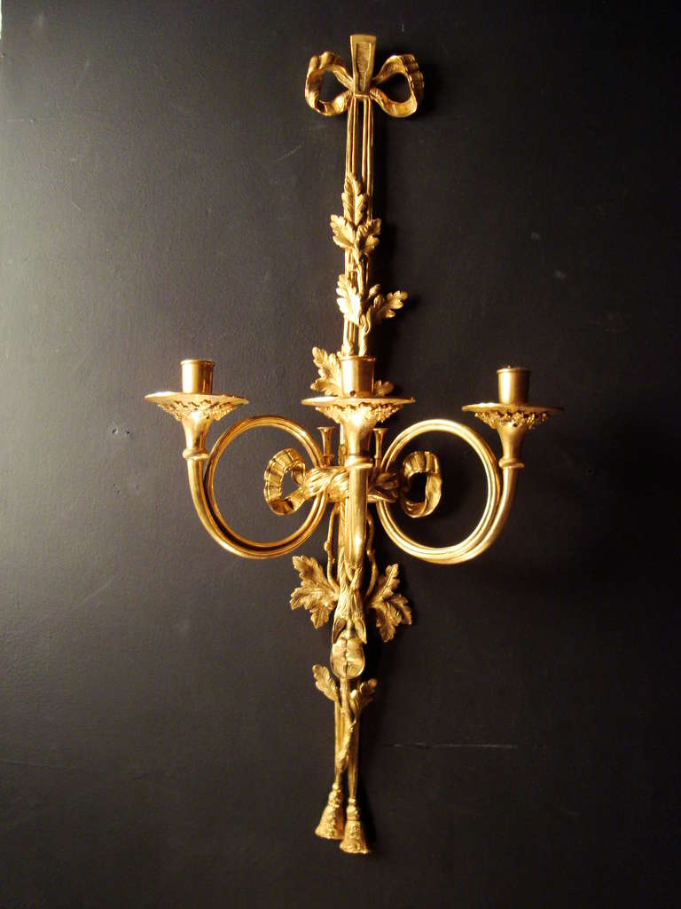 An important pair of Louis XVI style ormolu three branch wall-lights, after the model by Edme Jean Gallien (1720-1797) and Pierre Bureaux (born in 1728), France, mid 19th century, most possibly by either Raingo Frères or Beurdeley. 
The original