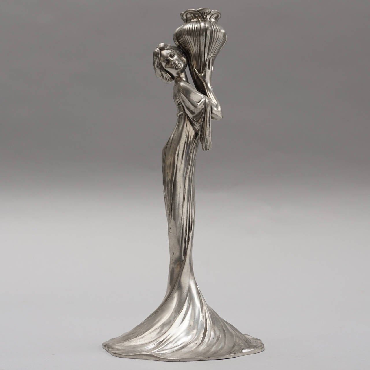 Delightful elegant maiden candlestick holder of silver plate Brittania metal. Manufactured by WMF in 1906.