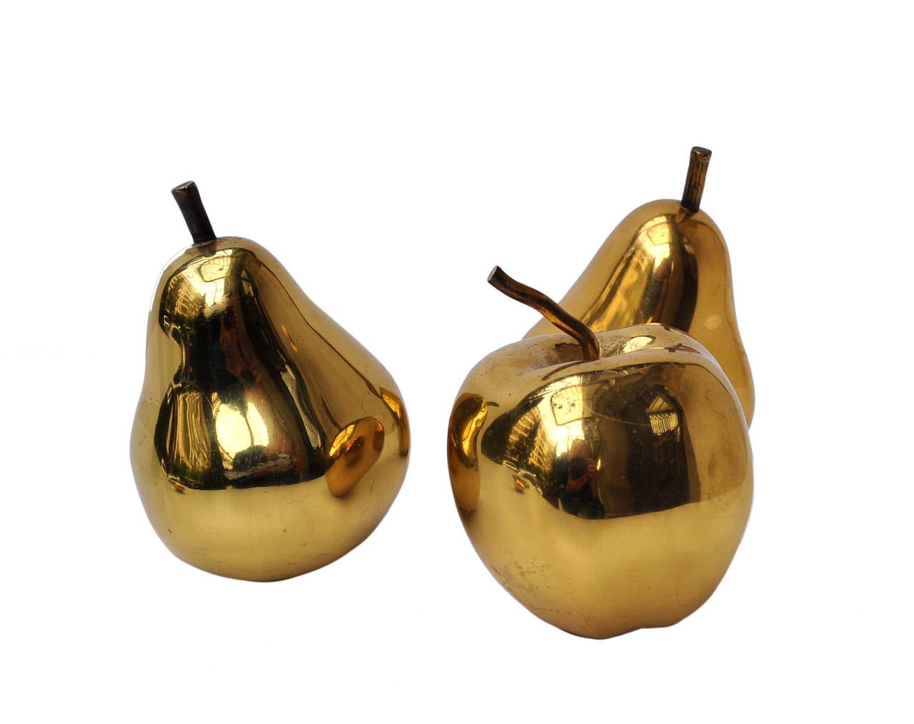 Three sublimely rendered bronze fruits alongside a mercurial stone minted in solid bronze. To the bottom of one fruit the substrate metal winks nickel plate beneath the gilt surface the core metal being bronze. The fruits are rendered to actual size