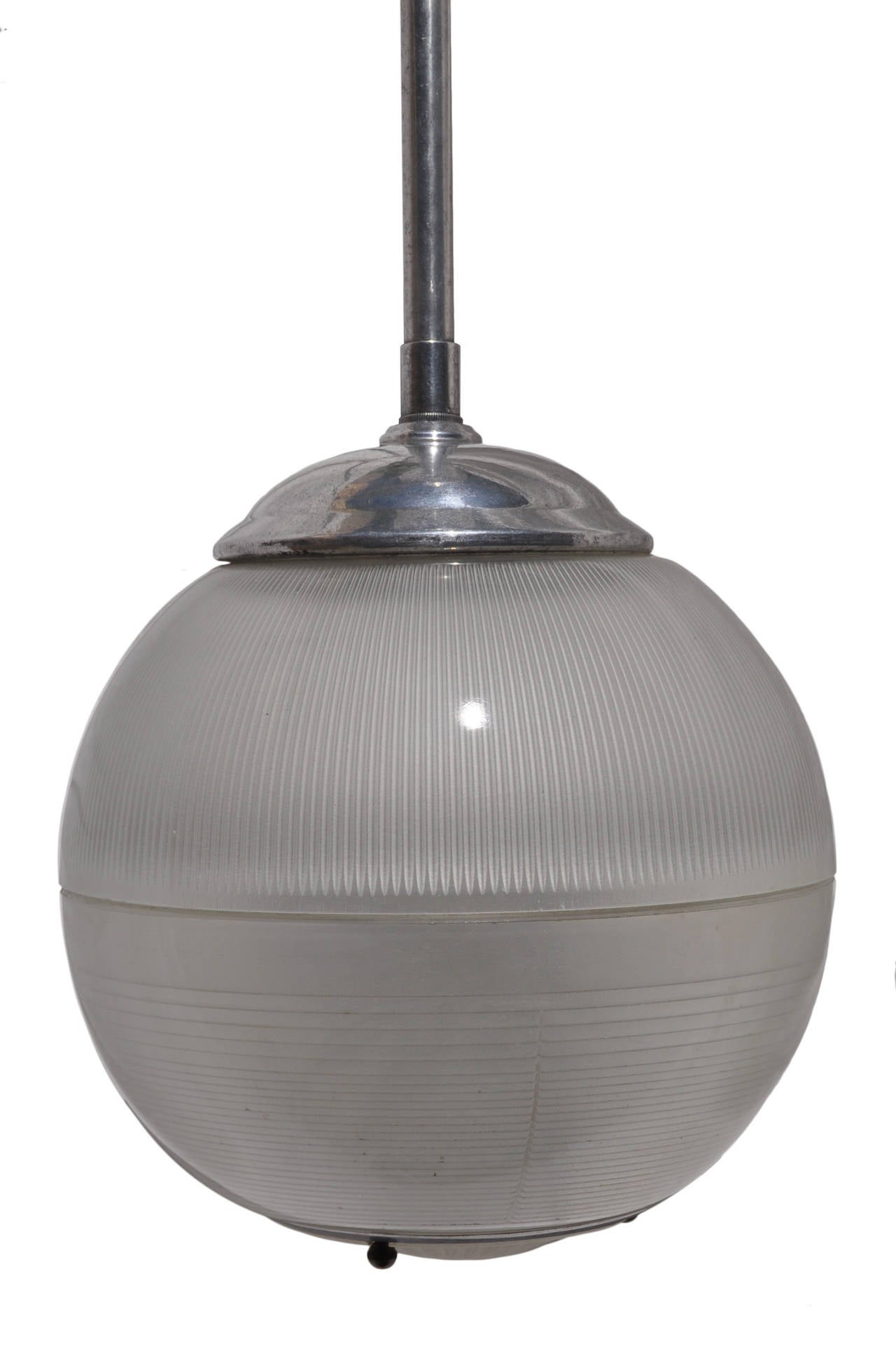 A good and rare edition of an industrial Holophane two part sphere pendant lamp with bottom insert and brass screw balls. The single socket within the sphere fits a standard bayonet bulb which is readily available internationally.