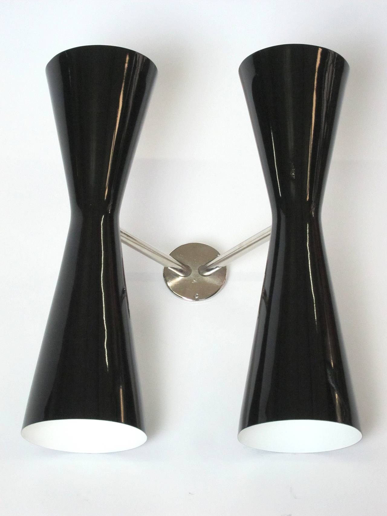 This beautiful 18 inch 4-light twin sconce, attributed to BAG Turgi Switzerland and manufactured in the 1950's, was completely restored. The shiny black lacquered aluminium shades are kept by a nickel-plated wall fixing.