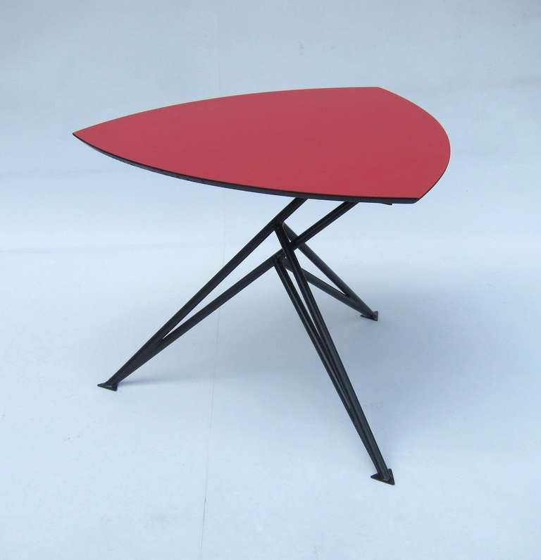 Unique aerodynamic sidetable, tripod base in black lacquered steel,
triangular wooden red lacquered top, restored.