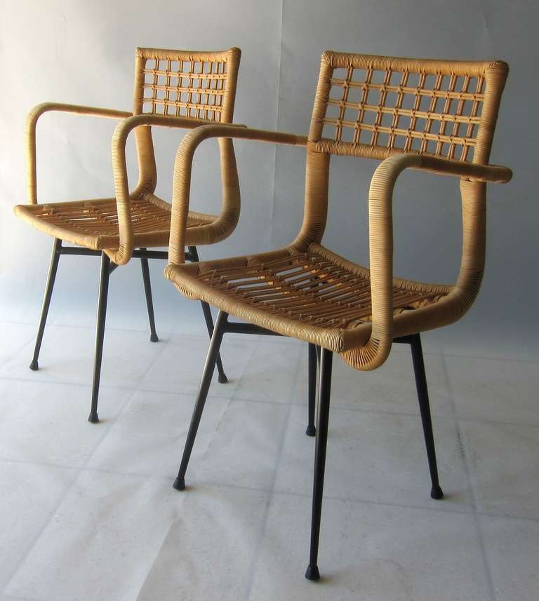 Very beautiful pair of 1950's italian rattan chairs reminding to the design of Gio Ponti. Both of the chairs are manufactured very carefully and are in excellent condition. The metal bases have been repainted, original rubber feet.