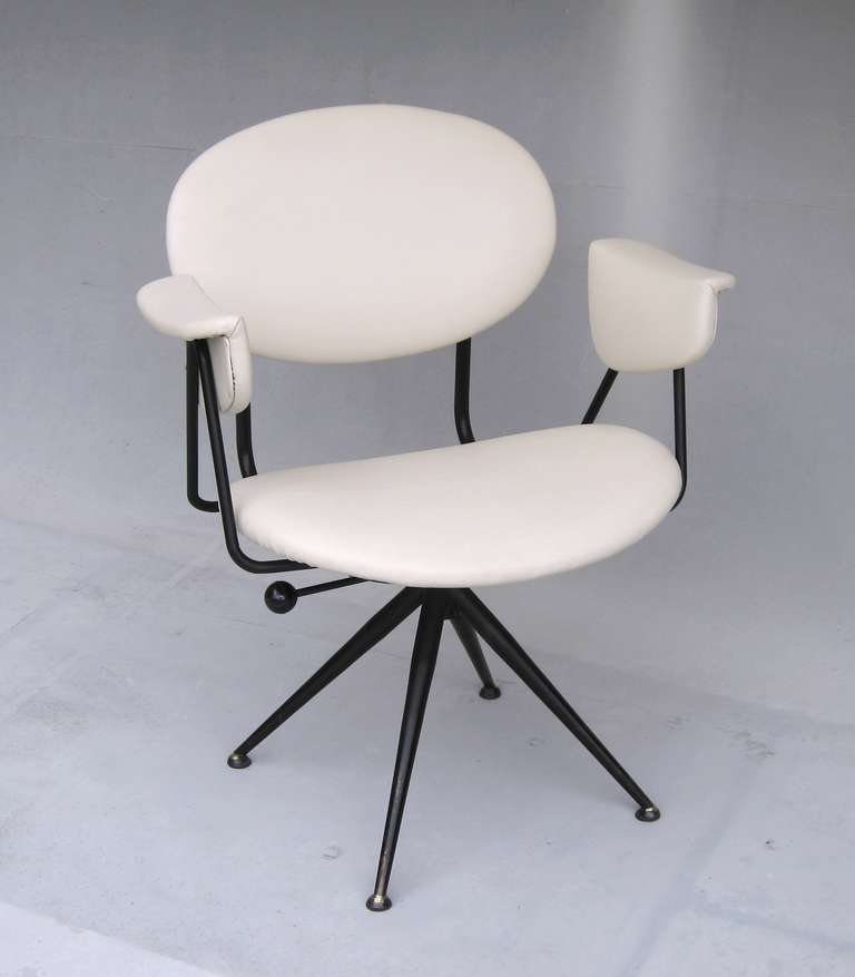 Characteristic italian 1950's chair in the style of Osvaldo Borsani, black lacquered 4-feet pyramid base, ivory vinyl covered comfortable seat, reupholstered a few years ago, pivot mechanism can be fastened