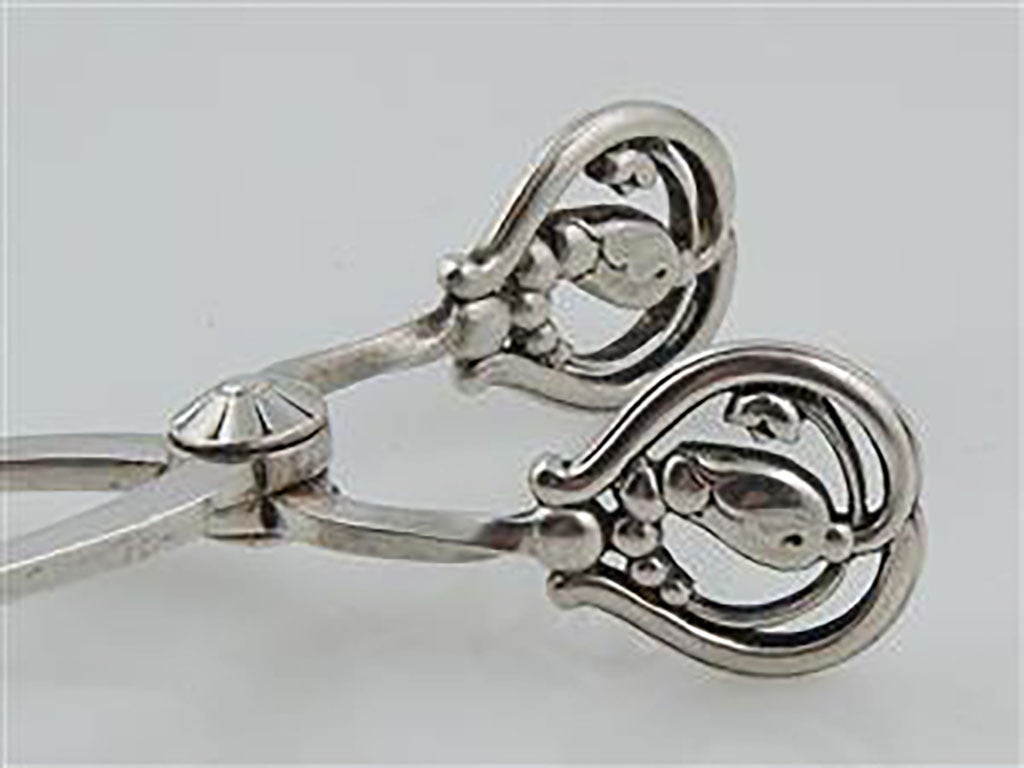 Georg Jensen sugar tang in sterling silver, 'blossom'.
Produced 1925-1932
In perfect condition. Hallmarked. Measures: 9.7 cm.
