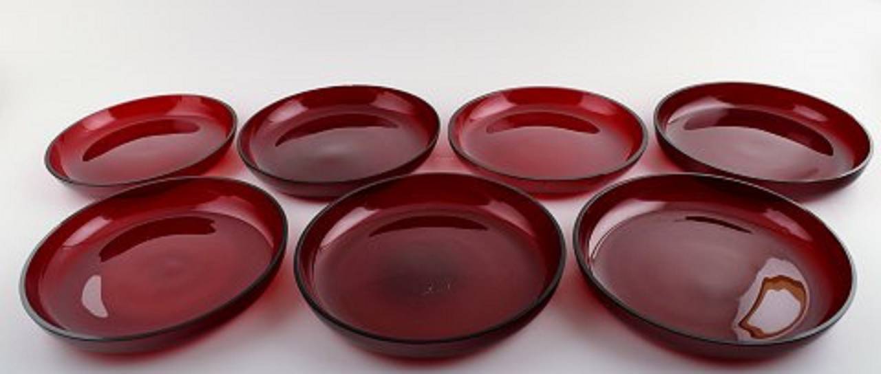 Seven plates in red glass, designed by Josef Frank.
Produced by: Reijmyre / Gullaskruf.
In good condition, some micro-chips.
Measures: 18 x 3 cm. Two plates, 1 cm, smaller.