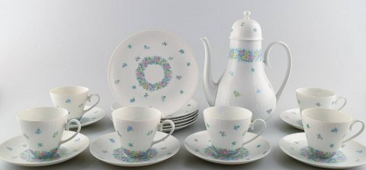 Linea Studio Rosenthal, Wiinblad. Servizio da caffè per sei persone con decorazione floreale, composto da sei tazze da caffè, sei piattini, sei piatti da dessert e caffettiera.
In perfette condizioni.
Caffettiera: 25 cm di altezza.