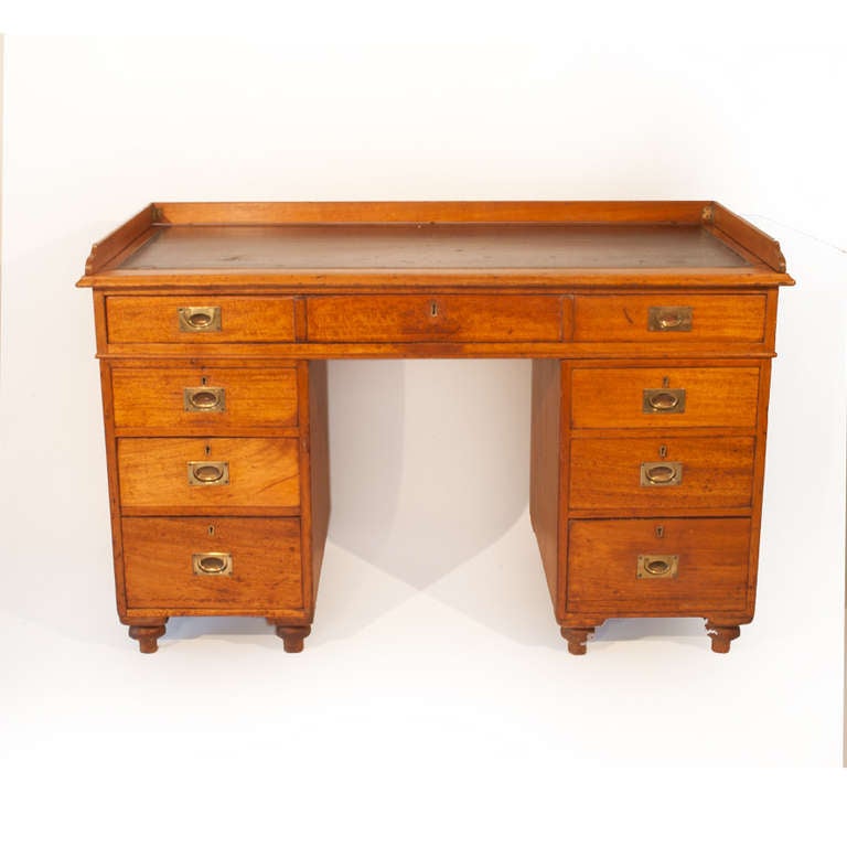A 19th century Pedestal Campaign Desk with leather inset, rectangular top with
hinged detachable gallery, above a long frieze drawer, each pedestal with three 
graduated drawers, flush brass handles and turned feet.  
82cm high 
126 cm wide
60