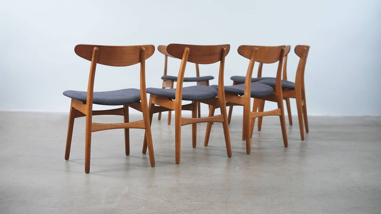 Wonderful set of 6 CH30 chairs designed by Hans Wegner for Carl Hansen, Denmark. These examples in oak with contrasting teak and new grey woolen upholstery. Fantastic exposed joint detail.