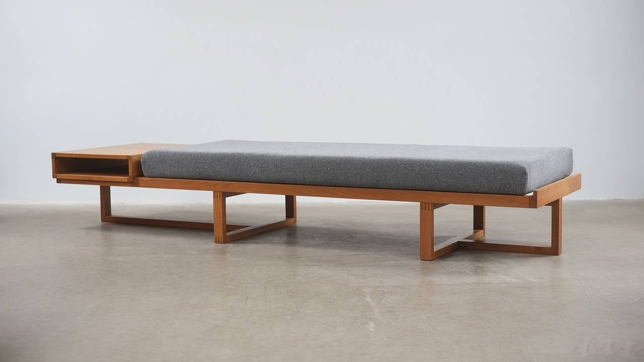 Amazing daybed with integral magazine table in solid oak with wonderful details designed and made in Denmark, 1960′s. Super high quality and ultra rare piece. New cushion with beautiful Fleck fabric.