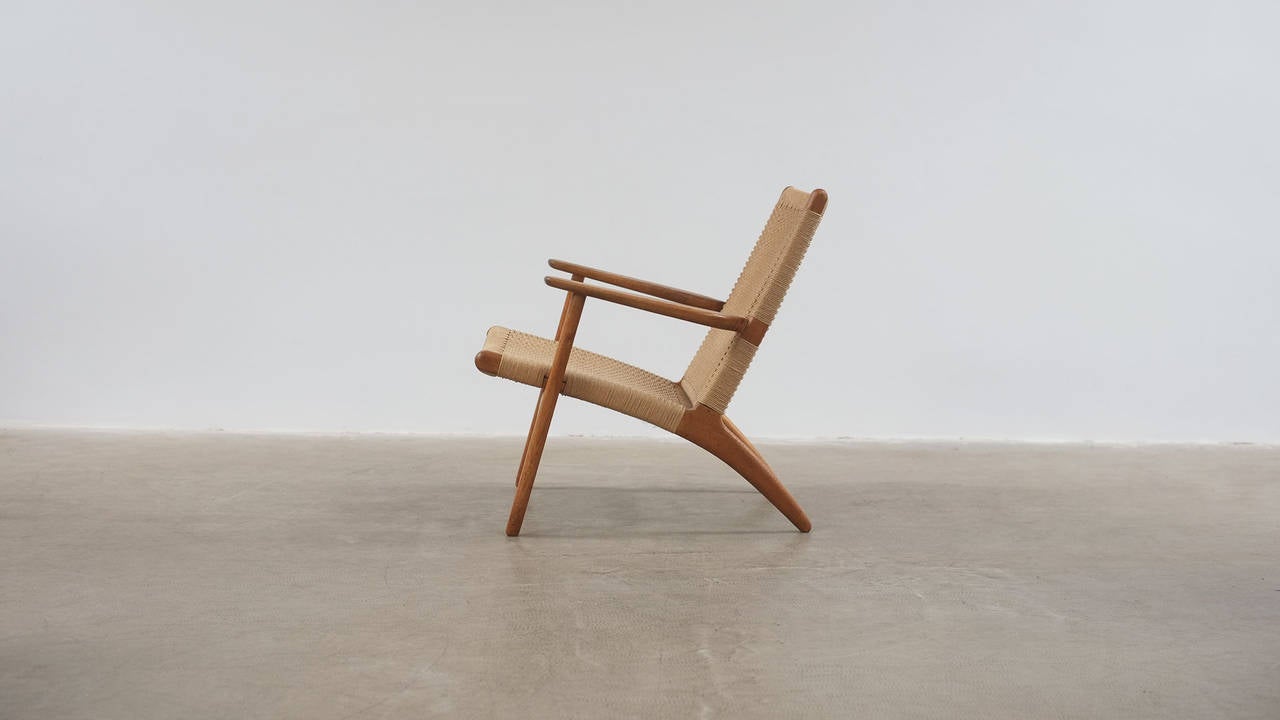 Beautiful CH25 Lounge chair designed by Hans Wegner for Carl Hansen, Denmark. Solid oak frame with papercord seat.  Very nice early example with superb patina.