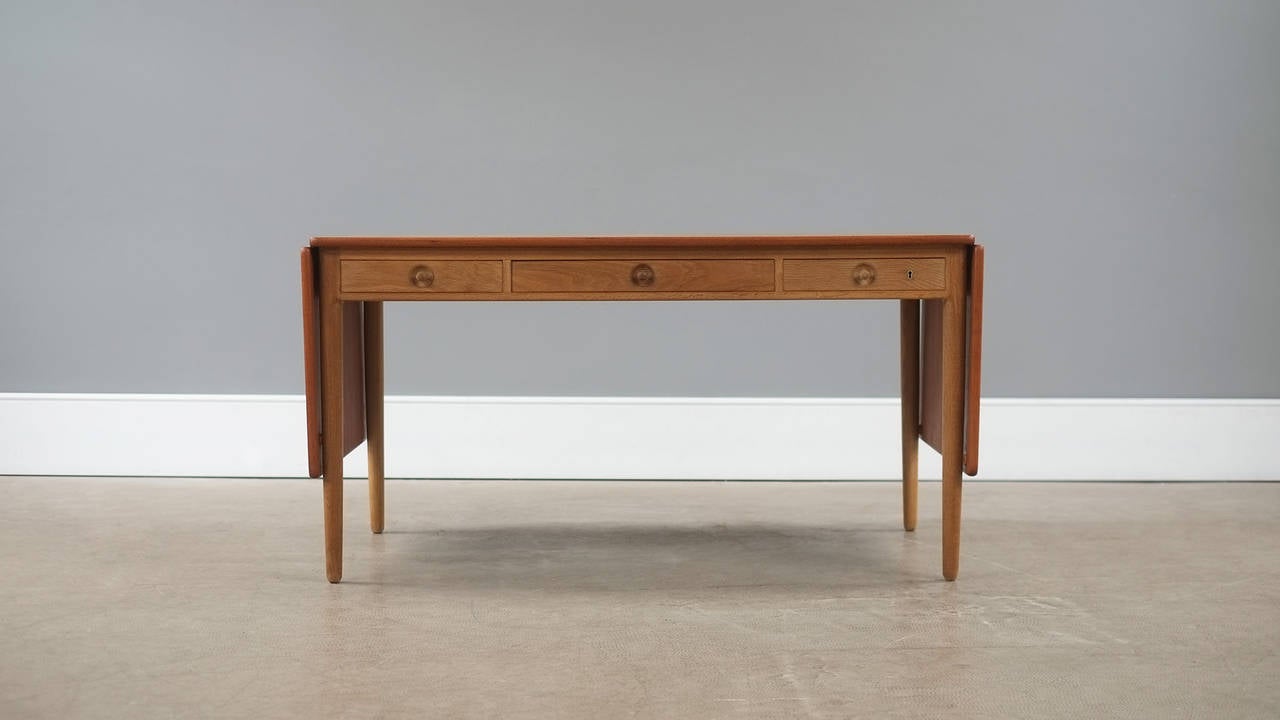 Wonderful AT305 desk with solid oak frame and contrasting teak top designed by Hans Wegner for Andreas Tuck, Denmark. Ultra high quality and famous piece with amazing details. Superb.
