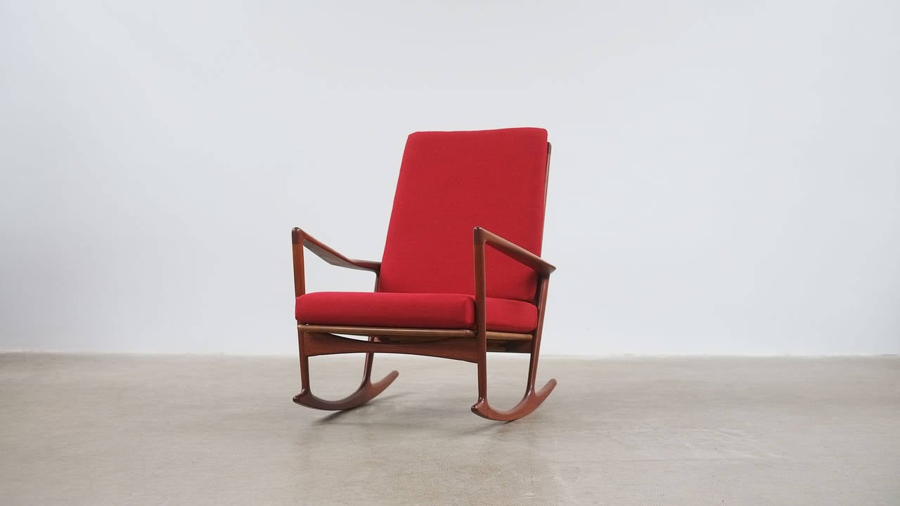 Wonderful rocking chair in solid teak designed by Ib Kofod Larsen for Selig, Denmark. Great quality and super comfortable chair with very sculptural arms. New cushions with new bright red fabric.