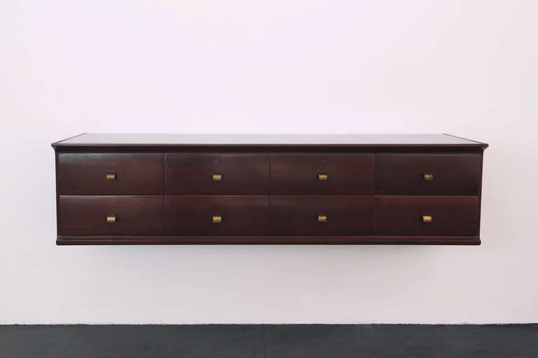 The simple form in rich burgundy mahogany is complemented by gently curving brass handles. A marriage of impeccable craftsmanship and timeless design, this practical piece of furniture would be a graceful addition to any collection.
Production by