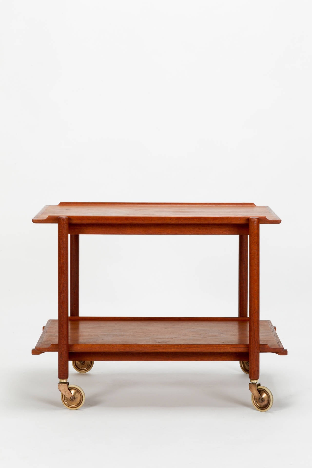 Lovely teak wood bar cart by Poul Hundevad, in Denmark 1960s. Made of a solid teak frame and two shelves, elegant and simple shape with beautiful details! The bottom shelf can be placed next to the top shelf to generate a bigger shelf space.