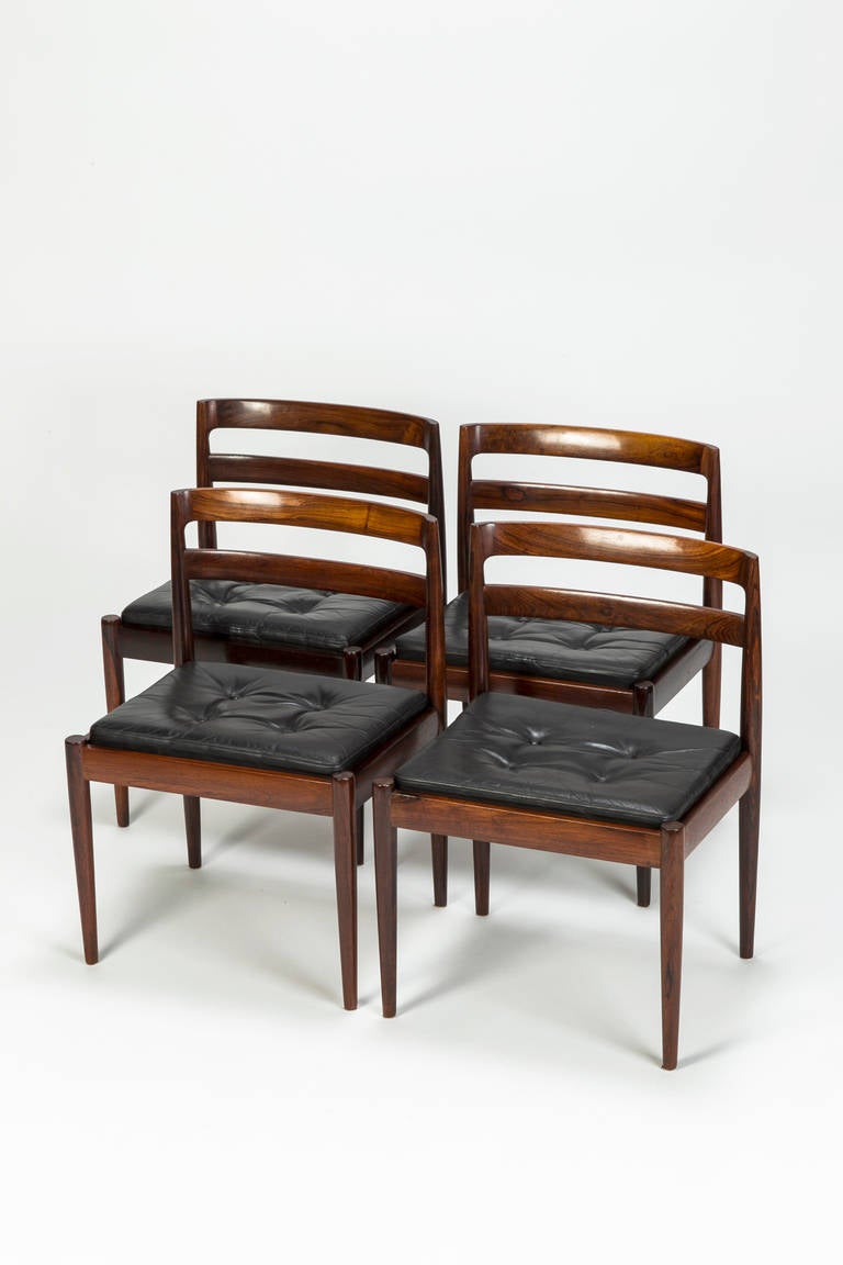 Set of four rosewood dining chairs model "301 Universe" designed by Kai Kristiansen for Magnus Olesen, Denmark, 1965. The frames are made of solid rosewood with beautiful grain patterns. Very simple and linear design. Seat cushions are