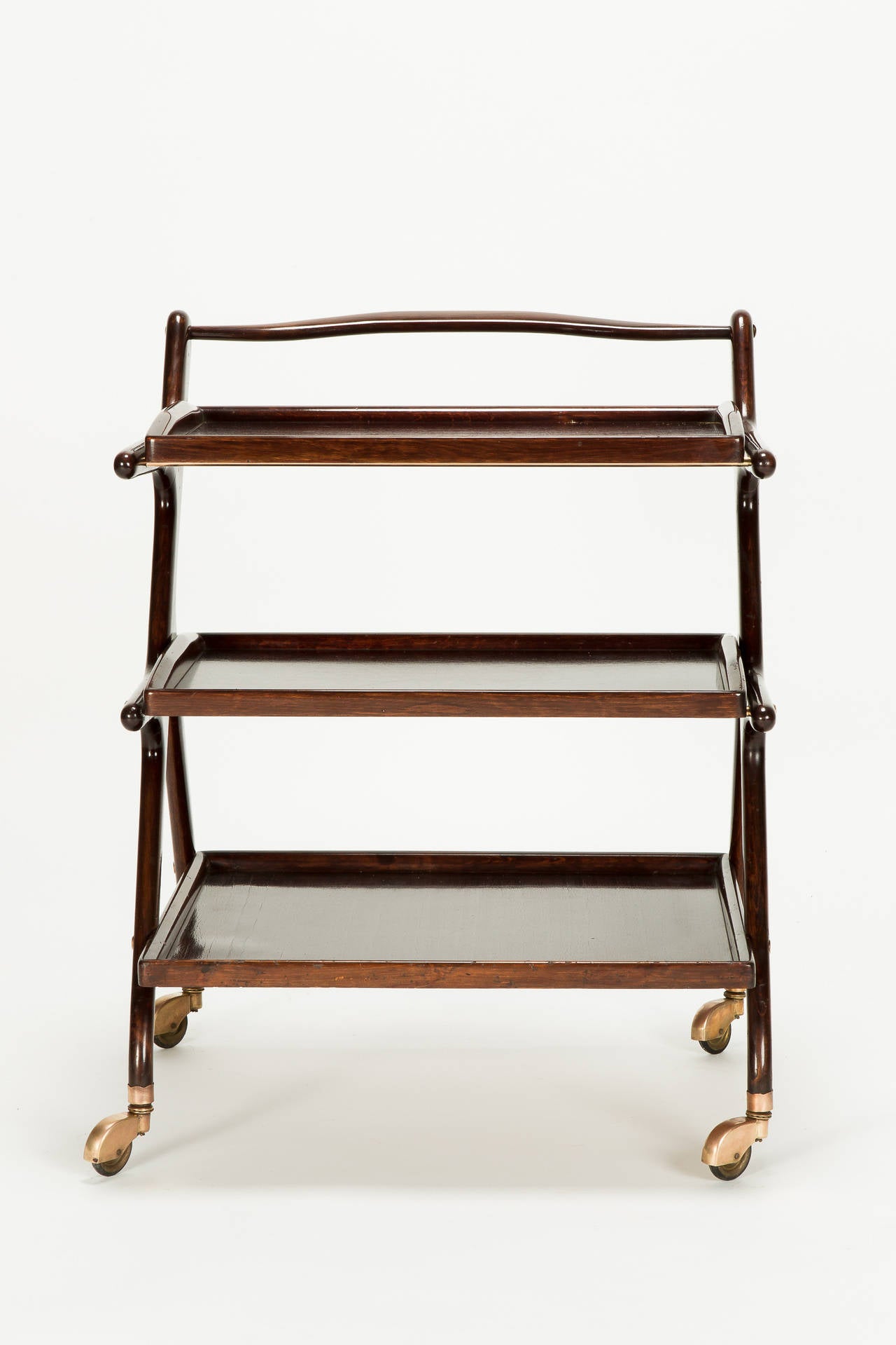 Italian mahogany serving trolley by Cesare Lacca, Italy, 1950s. Two removable trays, on brass wheels (slightly bronze colored), original finish.