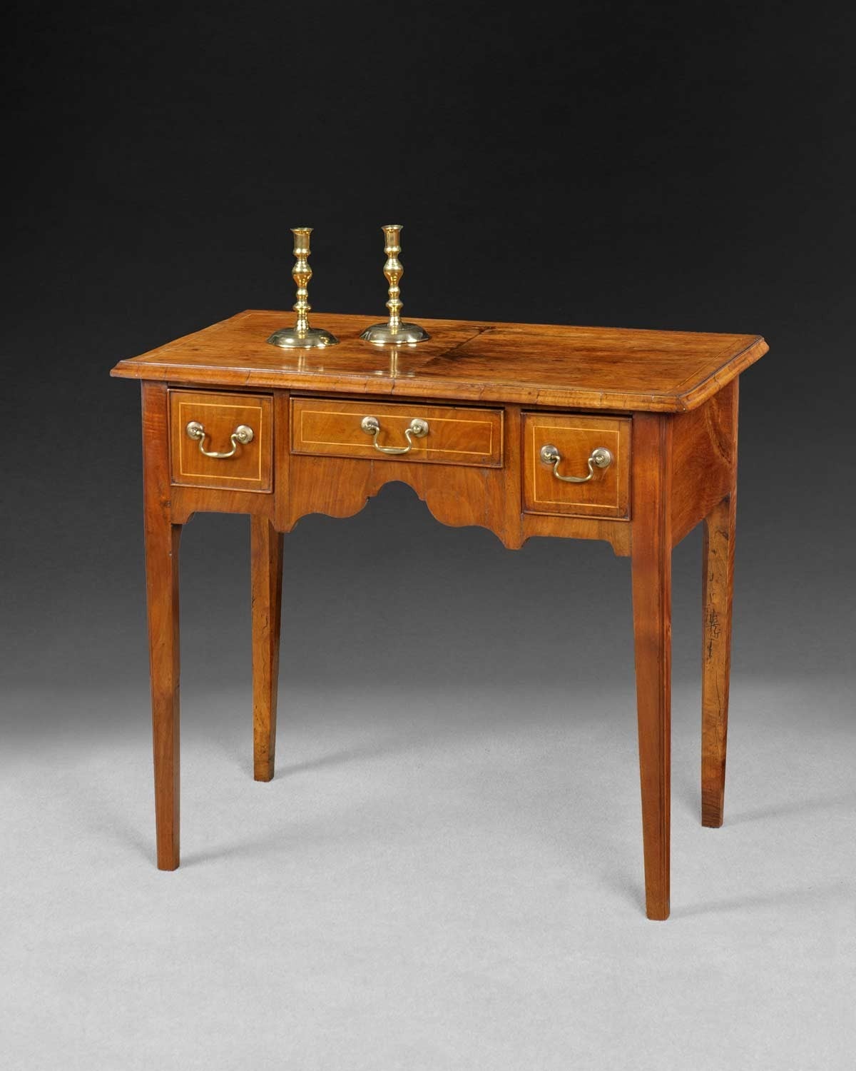 No:10431 

A very attractive Mid 18th. Century Walnut and Line Inlaid Lowboy, the quartered rectangular top above three frieze drawer, the shaped frieze between square section tapered legs.