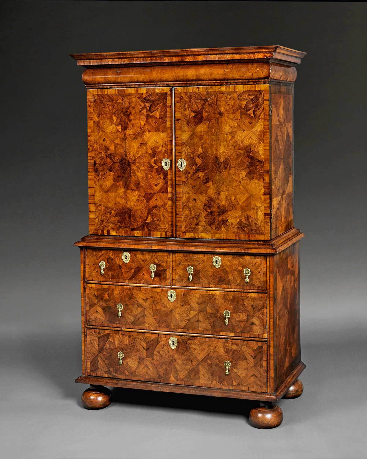 An extraordinary William and Mary period Kingwood Oyster veneered Rosewood Crossbanded Cabinet on Chest by Thomas Pistor, the moulded top above a bolection moulded secret drawer, oyster veneered to resemble a wave motion and above two doors each