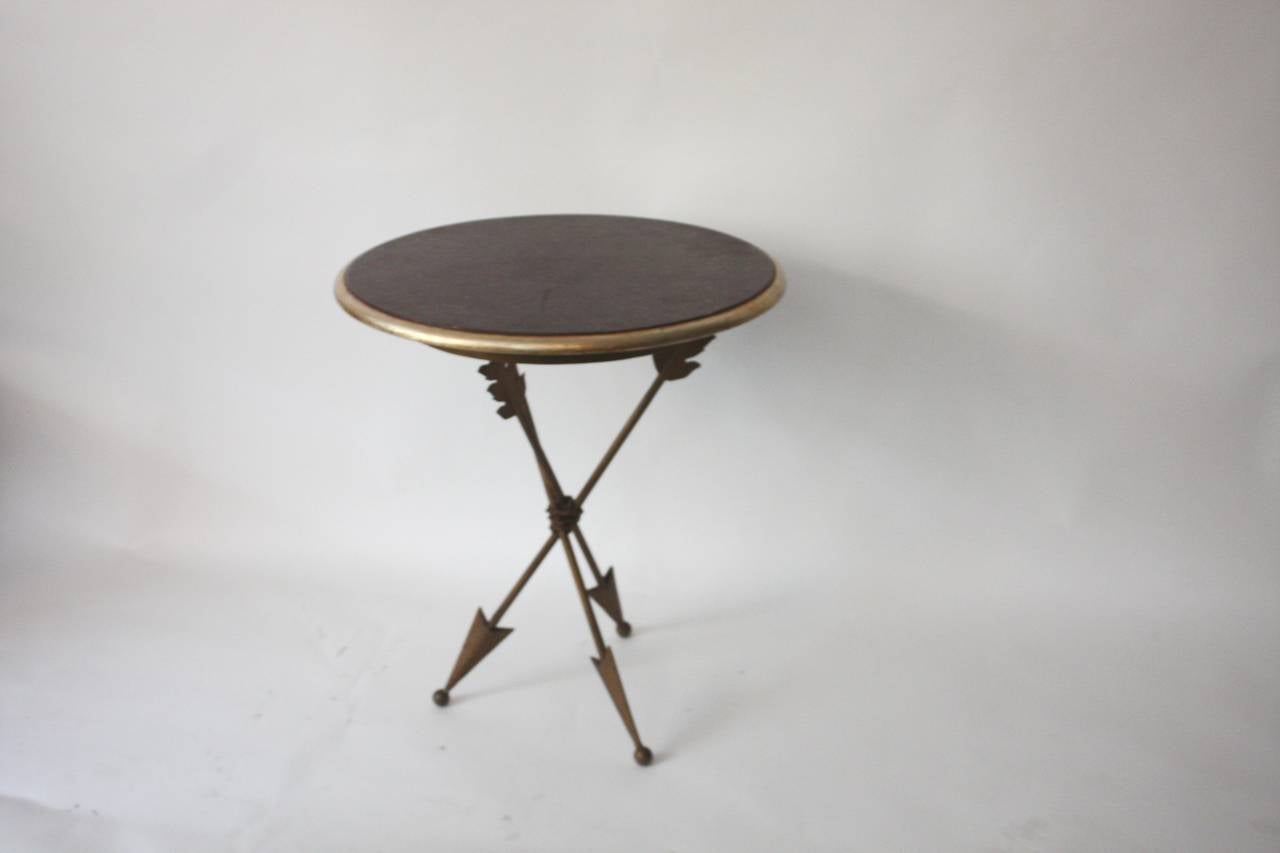 An occasional table 1950s French, finished on three iron gold painted arrows legs and painted wood top, can be used as occasional table or side table.