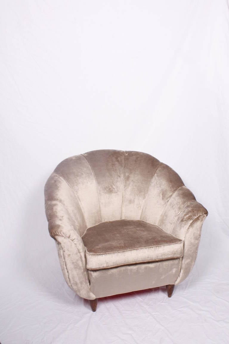 A pair of 40's Italian armchairs in the style of G.Ulrich, covered in cream velvet on wooden feet