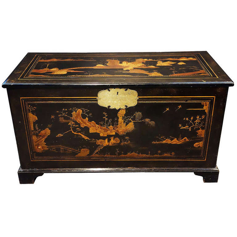 Black lacquerer Chinoiserie trunk with design that continues around all sides of the trunk.  Top, sides, front and back are equally beautiful decorated.  An original brass hardware plate frames the front lock and strong brass handles on each side