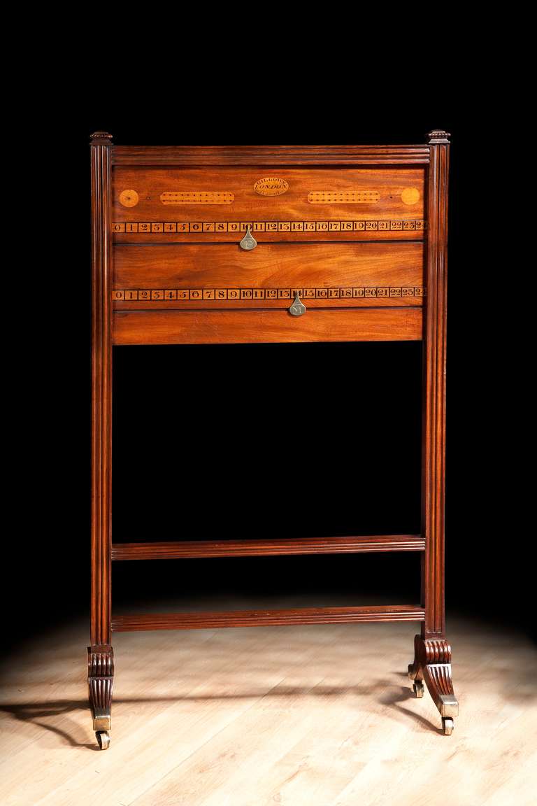 This mahogany antique billiards marker or score board made by Gillows of Lancaster and London has a rectangular panel with two slides, pegboards and spots marked out in a paler inlaid wood, all within a reeded frame with two stretchers supported on