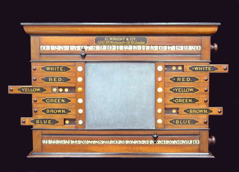 A beautiful billiards, snooker, or pool scoring cabinet in English oak manufactured by George Wright of London, circa 1880. A central slate panel flanked with 12 hand lettered sliding panels revealing ebony and boxwood stars, complete with two